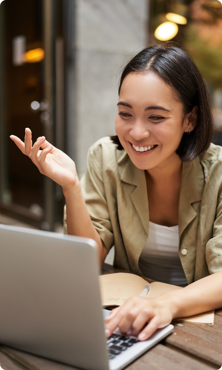 A person smiling and working on a laptop